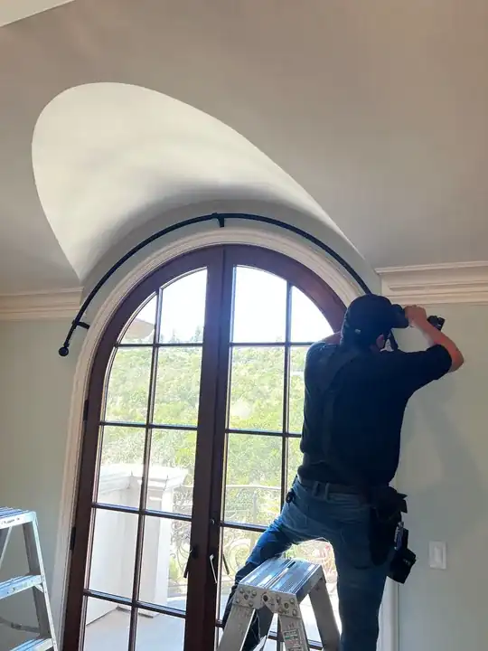 Alro installer measuring an arched residential window