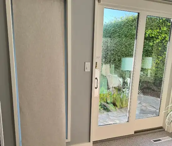 Light-filtering shade installed beside glass patio doors