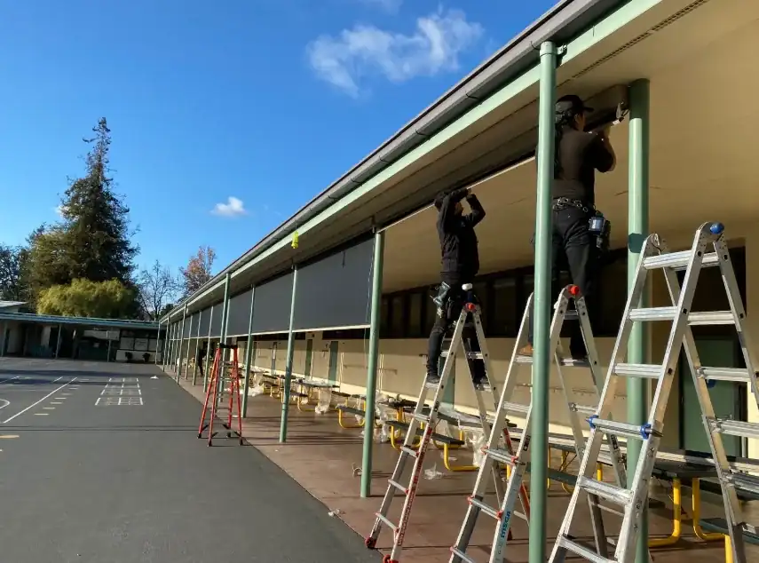 Alro installers fitting exterior window coverings at a school campus