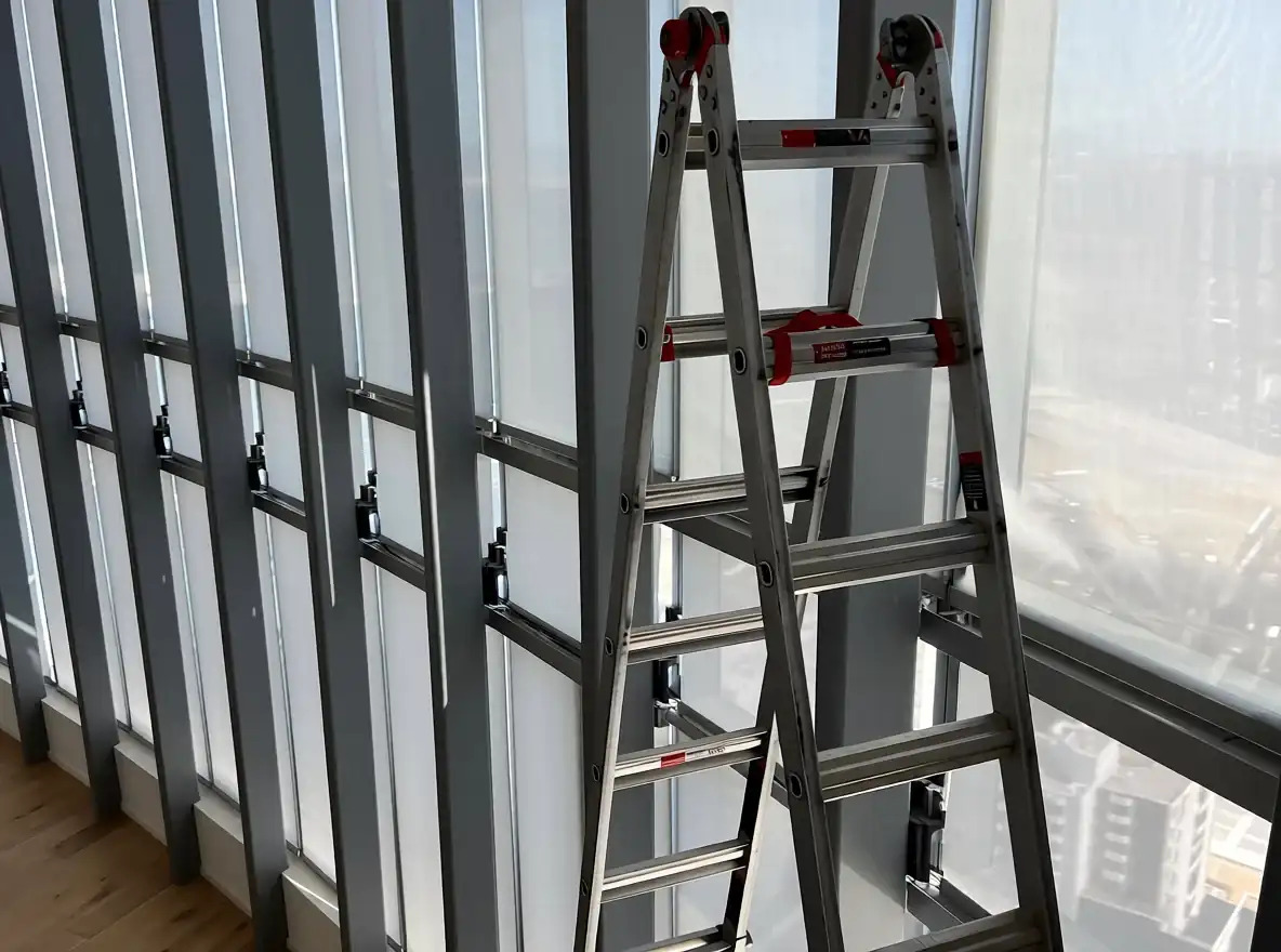 Commercial shade installation at a tall window