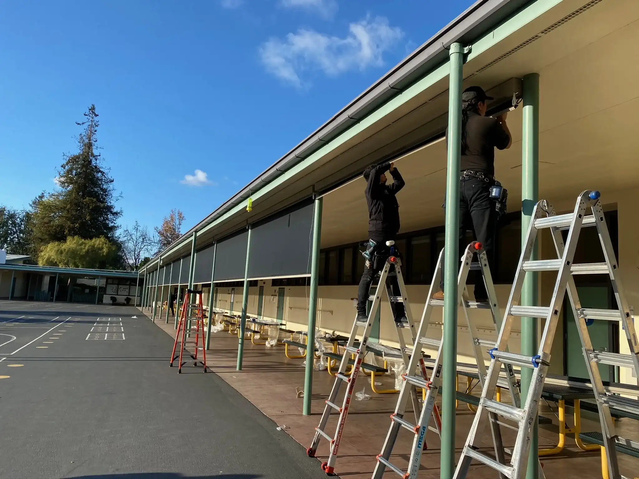 ALRO installation team working on window treatments at a school campus