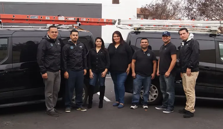 The Alro team standing with their branded work vans